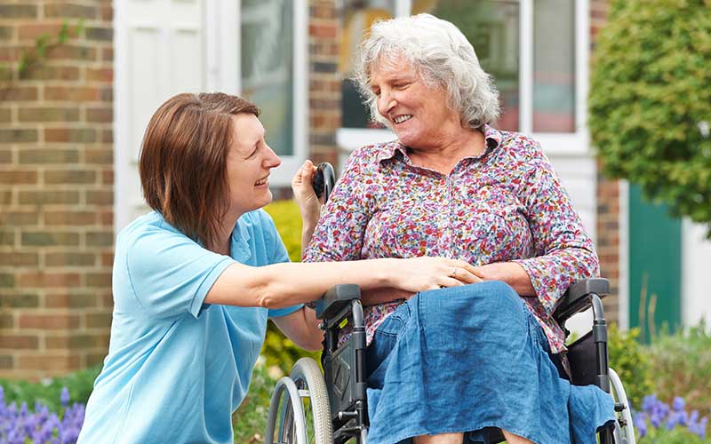 Support worker and wheelchair user both smiling
